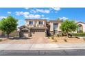 A two-story home with a three-car garage and desert landscaping at 1291 Rolling Sunset St, Henderson, NV 89052