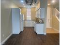 Bright kitchen featuring white cabinets, stainless steel appliances, and wood-look tile flooring at 137 Coronation Ave, Las Vegas, NV 89123