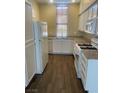Bright kitchen featuring white cabinets, granite countertops, and wood-look tile flooring at 137 Coronation Ave, Las Vegas, NV 89123
