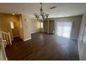 Open-concept living room with tile floors, modern lighting, and sliding glass doors to the backyard at 137 Coronation Ave, Las Vegas, NV 89123