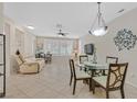 Open-concept living space with tile flooring, a dining area and a comfortable recliner at 2103 Poppywood Ave, Henderson, NV 89012
