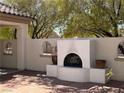 Outdoor fireplace nestled in a cozy courtyard with decorative accent windows at 2138 Fort Halifax St, Henderson, NV 89052