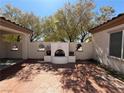 Spacious courtyard offers an outdoor fireplace with tiled flooring and mature trees at 2138 Fort Halifax St, Henderson, NV 89052