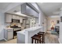 Charming kitchen with stainless steel appliances, breakfast bar, and gray cabinets at 227 N Lamb Blvd # B, Las Vegas, NV 89110
