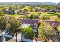 Stunning aerial view of a home on a golf course with mature trees and mountain views at 2505 Showcase Dr, Las Vegas, NV 89134