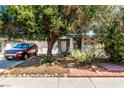 Charming single-story home with mature landscaping and a tree providing shade over the front yard and driveway at 2600 E Owens Ave, North Las Vegas, NV 89030