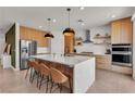 Modern kitchen featuring a waterfall island with seating, sleek cabinetry, stainless steel appliances, and stylish pendant lighting at 2601 Gallarate Dr, Henderson, NV 89044