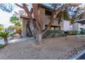 Exterior view showing desert landscaping and stairwell access to upper floors with an overhanging tree for shade at 2606 Durango Dr # 181, Las Vegas, NV 89117