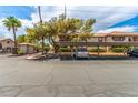Exterior condo parking area with mature trees and landscaping, carports with parked truck and gate to residential complex at 2606 Durango Dr # 181, Las Vegas, NV 89117