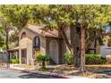 Two-story condo building showcasing stucco architecture, a tile roof, trimmed greenery, arched doorway and second story staircase at 2606 Durango Dr # 181, Las Vegas, NV 89117