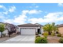 Inviting single-story home featuring desert landscaping, a spacious driveway, and an attached two-car garage at 2651 Solera Moon Dr, Henderson, NV 89044