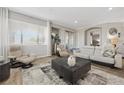 Bright living room boasts neutral colors, wood floors, and sliding glass door access to outdoor living at 30 Via Mantova # 109, Henderson, NV 89011