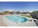 Backyard with a private in-ground swimming pool, gray concrete surround, and some green space at 3905 Casa Grande Ave, Las Vegas, NV 89102