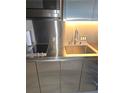 Close-up of a sleek stainless steel kitchenette with modern appliances and a minimalist design at 4381 W Flamingo Rd # 3109, Las Vegas, NV 89103