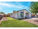 This backyard features an artificial lawn, rock landscaping, and privacy fencing for outdoor enjoyment at 4432 Ash Ave, Las Vegas, NV 89110