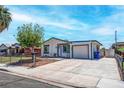 A charming single-story house with an attached garage and a well-kept front yard with a chain-link fence at 4432 Ash Ave, Las Vegas, NV 89110