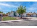 Exterior of a single-story home with a manicured front yard, a mature tree, and gated lawn at 4432 Ash Ave, Las Vegas, NV 89110