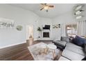 Living room with vaulted ceilings, a fireplace, wood floors, and access to the backyard at 504 Crony Ave, Henderson, NV 89011