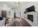 Spacious living room with a fireplace, wood floors, vaulted ceiling, and plenty of seating at 504 Crony Ave, Henderson, NV 89011