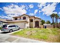 Lovely two-story house with a three-car garage, well-kept lawn and landscaping, sunny sky at 5412 Rainbows End Dr, Las Vegas, NV 89149