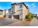 View of the home's side and rear showcasing a two-car garage with a long driveway and manicured landscaping at 6141 May River St, Las Vegas, NV 89148