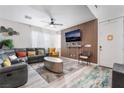 Stylish living room featuring a modern sectional sofa, sleek coffee table, and a decorative wood-paneled accent wall at 6141 May River St, Las Vegas, NV 89148