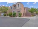 Two-story tan home featuring an attached garage, and landscaped front yard at 6599 Netherseal Ave, Las Vegas, NV 89139