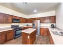 Well-lit kitchen with stainless steel appliances, wooden cabinets, and a central island, offering both style and functionality at 6623 Hurkling Stone Ave, Las Vegas, NV 89139