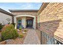 Inviting front entrance with stone accents, arched entry, and desert landscape at 7165 N Grand Canyon Dr, Las Vegas, NV 89149
