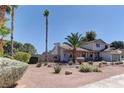 A charming home with desert landscaping and a mature palm tree in the front yard at 893 Fairway Dr, Boulder City, NV 89005