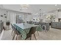 Open concept kitchen and dining area with stylish light fixtures and stainless steel appliances at 11009 Pentland Downs St, Las Vegas, NV 89141