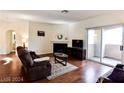 Inviting living room with a fireplace, balcony access, and hardwood flooring at 1605 Crimson Hills Dr # 204, Las Vegas, NV 89128