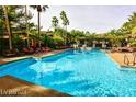 Large community pool surrounded by lush landscaping and lounge chairs at 1605 Crimson Hills Dr # 204, Las Vegas, NV 89128