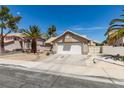 Charming single-story home featuring a two-car garage, desert landscaping and mature palm trees at 1824 Dawn Ridge Ave, Henderson, NV 89074