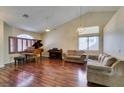 Cozy living room features hardwood floors, vaulted ceilings, with piano and natural light at 1824 Dawn Ridge Ave, Henderson, NV 89074
