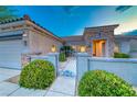 Inviting home showcasing an elegant gated courtyard, desert landscaping, and a stone accented facade at 2215 Bannerwood St, Henderson, NV 89044