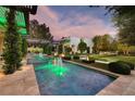 Luxury backyard featuring a long pool, fire features, and manicured landscaping at 2323 Pinto Ln, Las Vegas, NV 89107