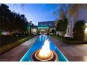Backyard features a long pool with fire bowls and a meticulously manicured lawn at 2323 Pinto Ln, Las Vegas, NV 89107