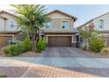Charming two-story home with a well-manicured front yard and a brick driveway at 361 Andy Wheeler Dr, Henderson, NV 89011
