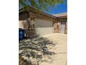 Attached garage with stone accents and ample driveway parking at 3910 Internet Ave, North Las Vegas, NV 89031