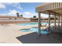 Outdoor community pool with sun chairs and hot tub area, perfect for relaxation and leisure at 4940 Mascaro Dr, Las Vegas, NV 89122