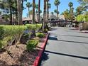 Community entrance with lush landscaping, palm trees and secured gate at the Tuscan Villas Condominiums at 5055 W Hacienda Ave # 1161, Las Vegas, NV 89118