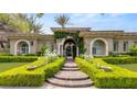 Inviting single-story home featuring arched entryway adorned with lush greenery and manicured hedges at 517 Spruce Canyon St, Las Vegas, NV 89144
