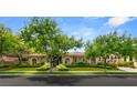 Charming single-story home showcasing arched windows and a meticulously landscaped front yard with mature trees at 517 Spruce Canyon St, Las Vegas, NV 89144