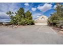 Inviting home with a three-car garage, spacious driveway, mature trees, and well-maintained landscaping at 5180 N Dapple Gray Rd, Las Vegas, NV 89149