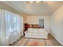 Bright living room featuring a white sofa, patterned rug, and large window with sheer curtains at 533 Date St, Boulder City, NV 89005