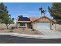 Charming single-story home with a two-car garage, desert landscaping, terracotta roof, and solar panels at 5638 Morning Song Cir, North Las Vegas, NV 89031
