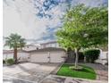 Charming home with a two-car garage, lush landscaping, and brick-lined driveway, creating curb appeal at 760 Camino La Paz, Henderson, NV 89012