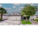 Charming home with a two-car garage, lush landscaping, and brick-lined driveway, creating curb appeal at 760 Camino La Paz, Henderson, NV 89012