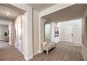 Bright entryway with a bench, decorative mirror, and gray wood-look flooring at 7665 Serenity Bay Ln # Lot 58, North Las Vegas, NV 89084